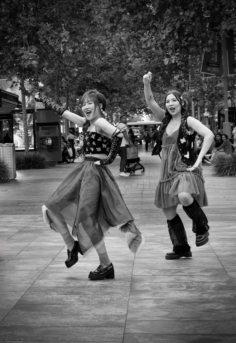 Two young Asian girls dancing in the street