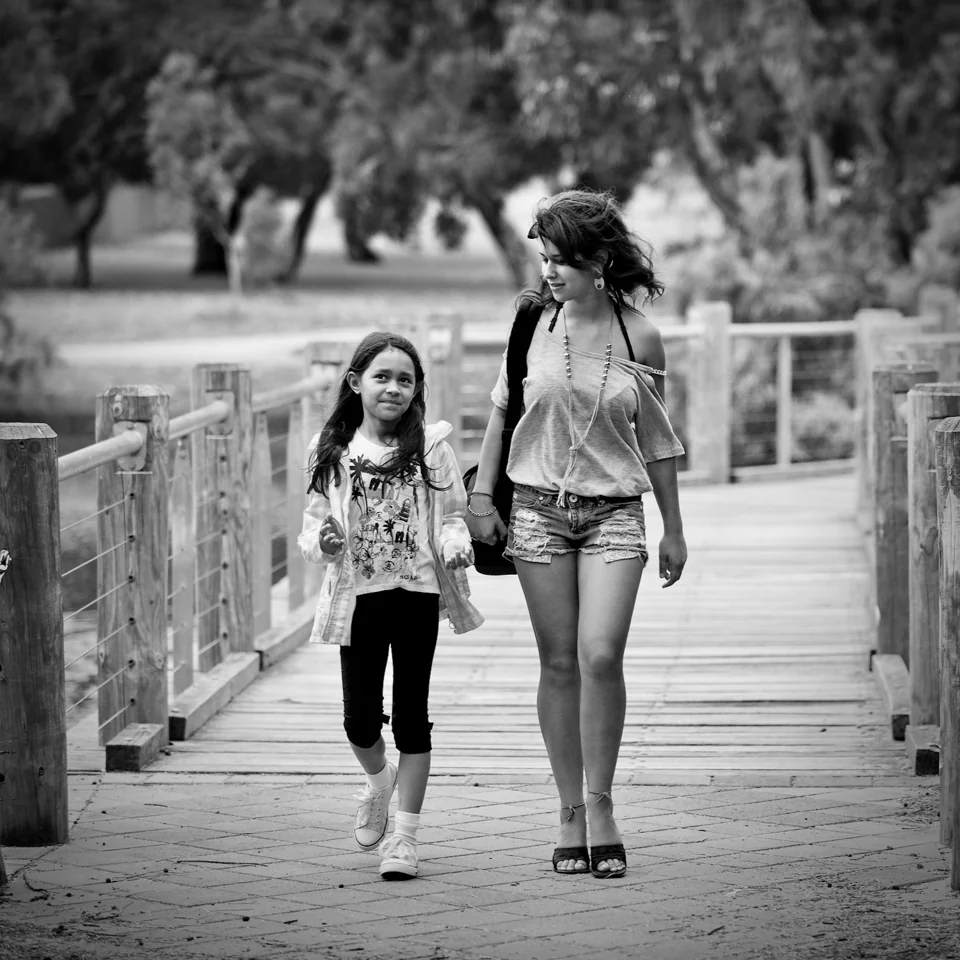 A woman and child walking over a wooden bridge — photograph by Peter Pickering