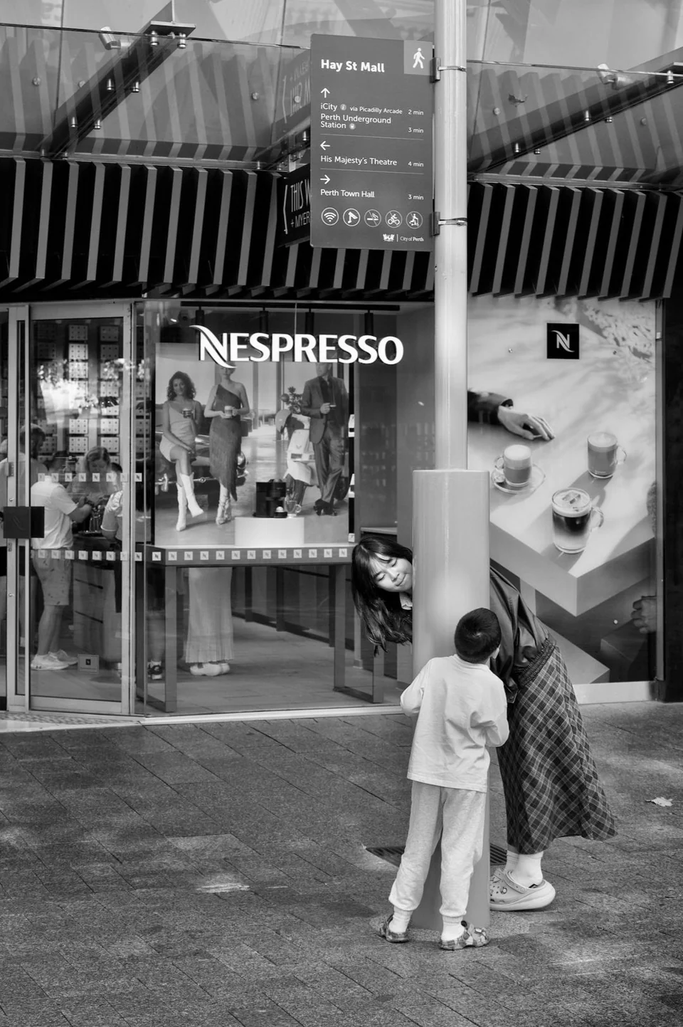 Decisive moment - mother and son playing hide & seek in the street