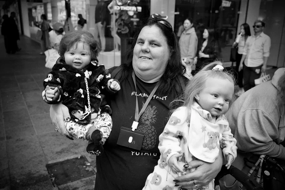 A woman carries two young children — photograph by Peter Pickering