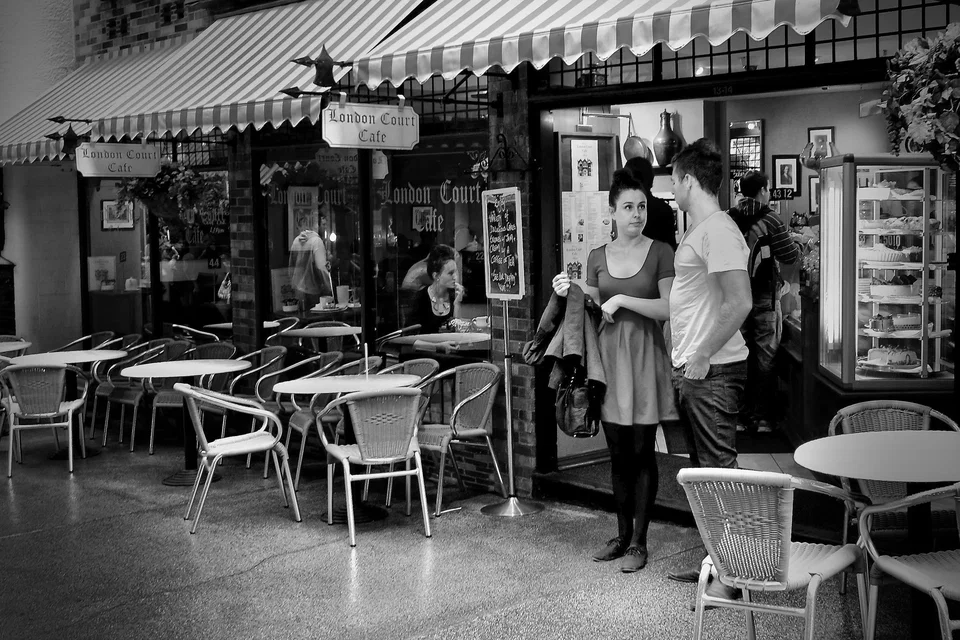 A woman sits outside a café — photograph by Peter Pickering