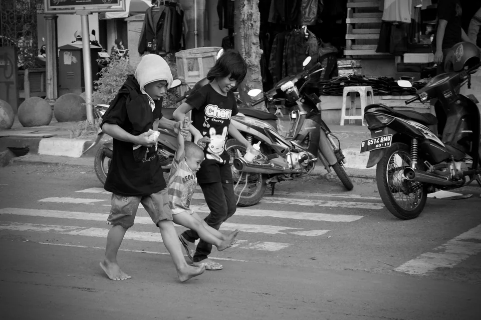 Children run across a street — photograph by Peter Pickering
