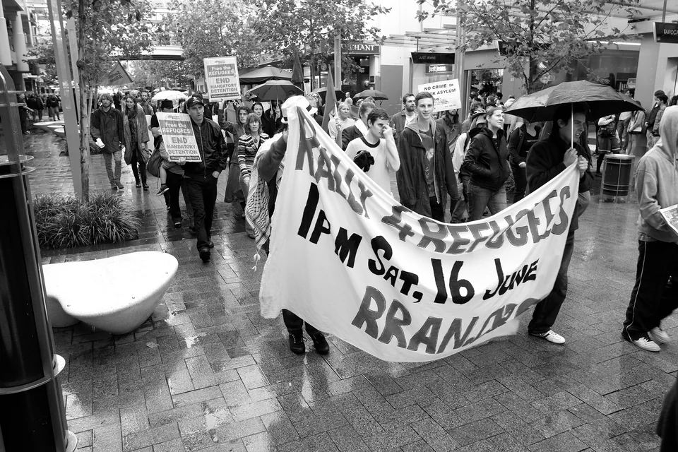 Marchers carry a banner through a city street — photograph by Peter Pickering