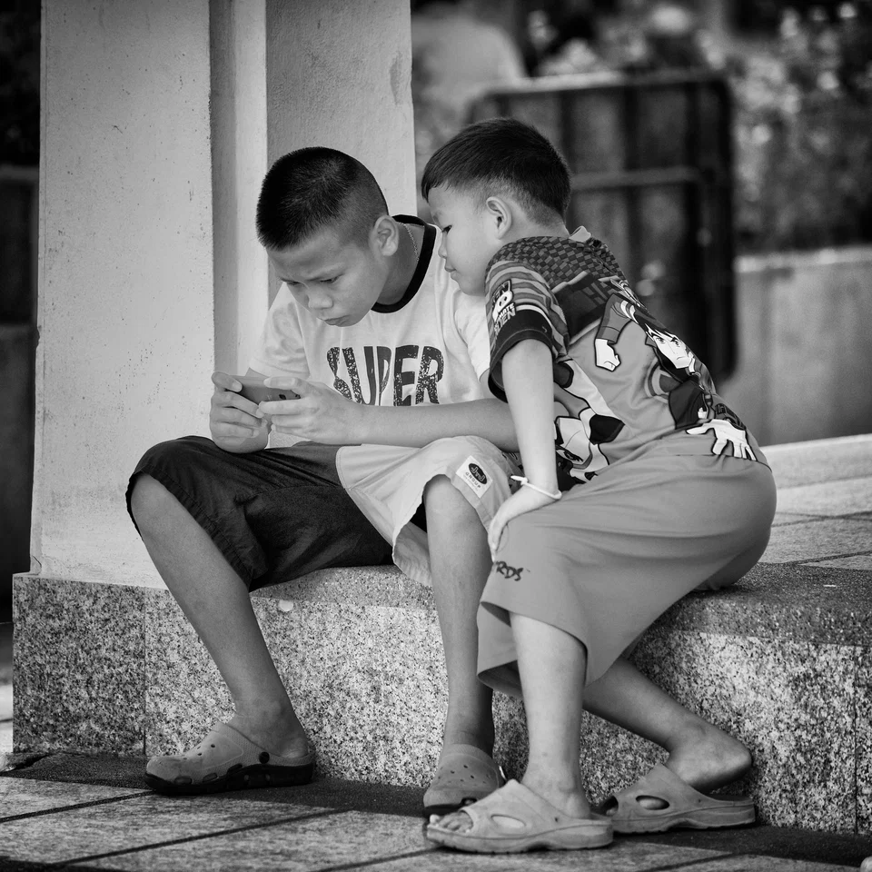 Two children sit together on a step — photograph by Peter Pickering