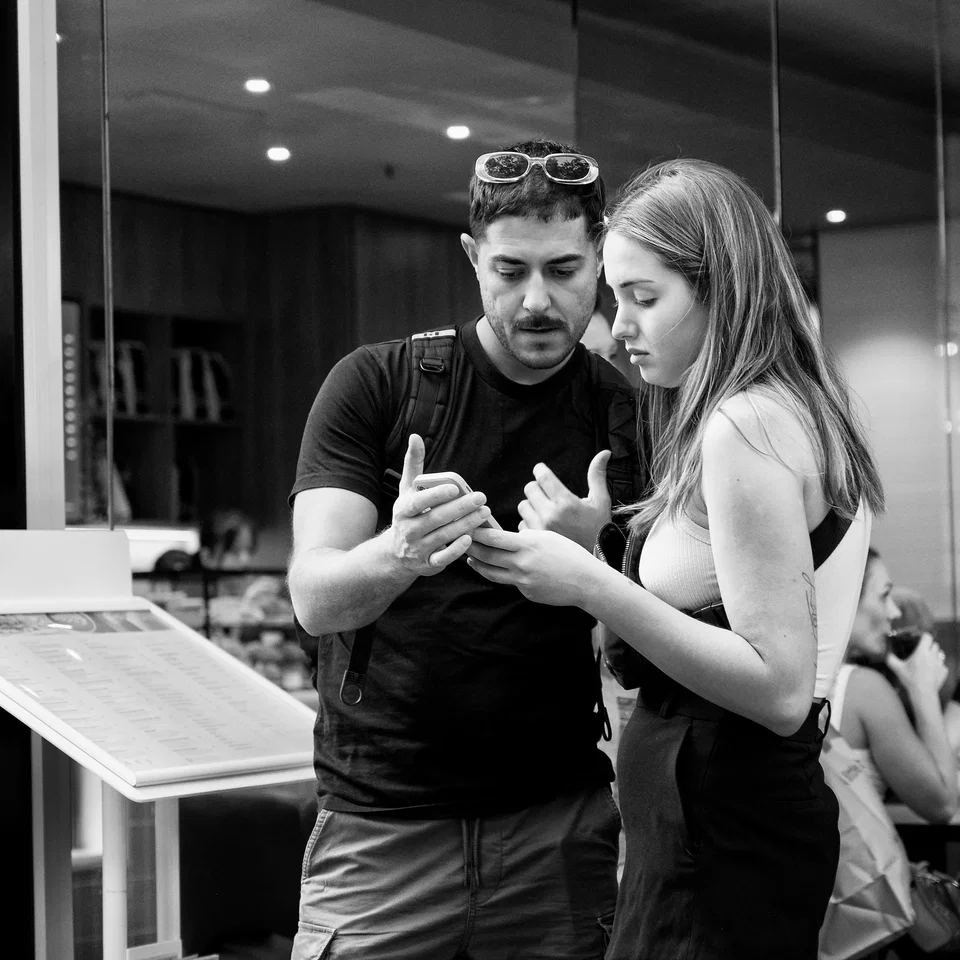 Two people study something in their hands — photograph by Peter Pickering