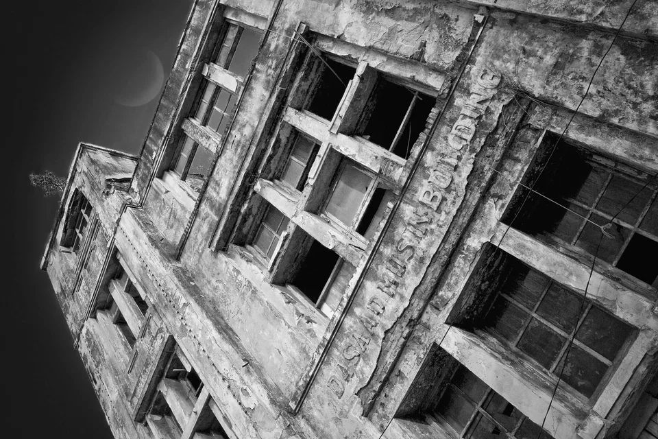 A tilted view of a weathered building façade — photograph by Peter Pickering