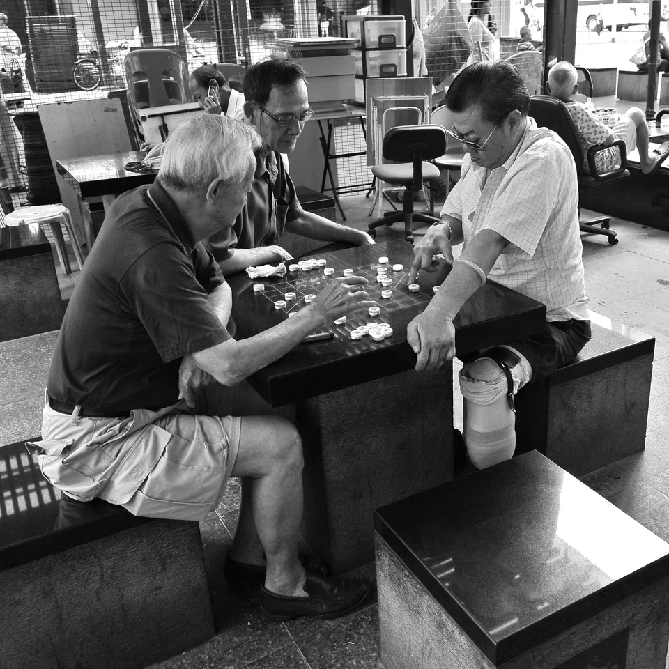 People play a tabletop game outside a café — photograph by Peter Pickering