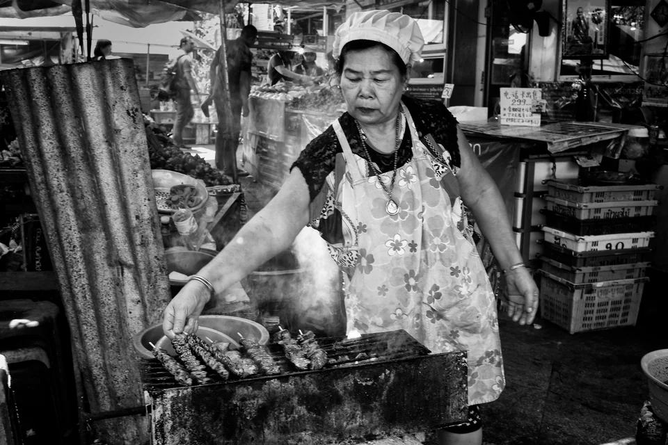 A vendor cooks at a street-side stall — photograph by Peter Pickering