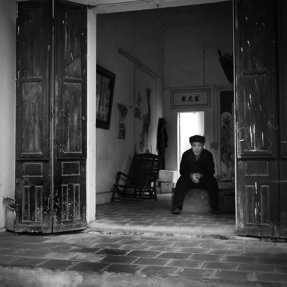 A seated figure framed by a deep doorway — photograph by Peter Pickering