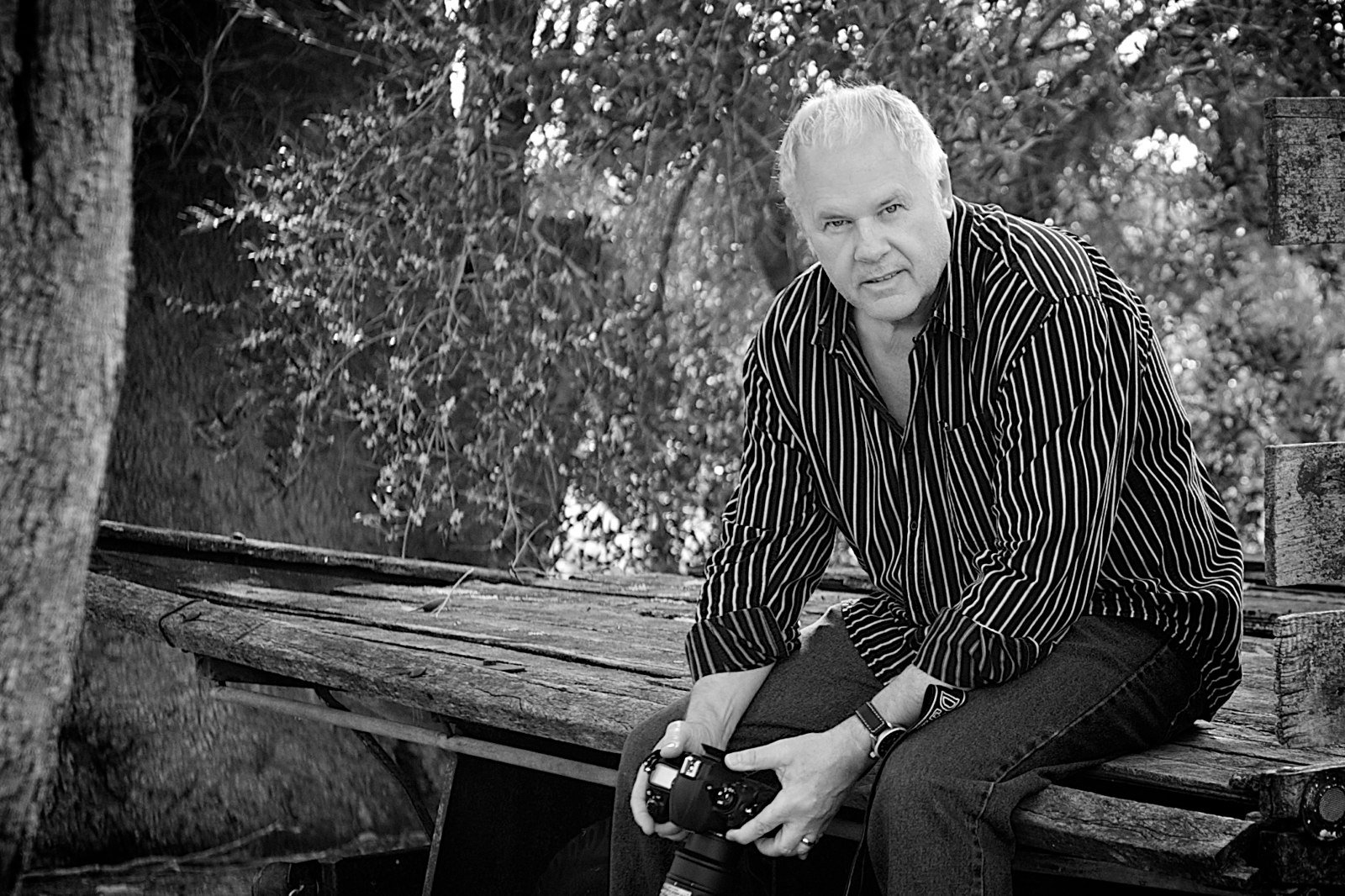 Peter Pickering seated outdoors holding his camera